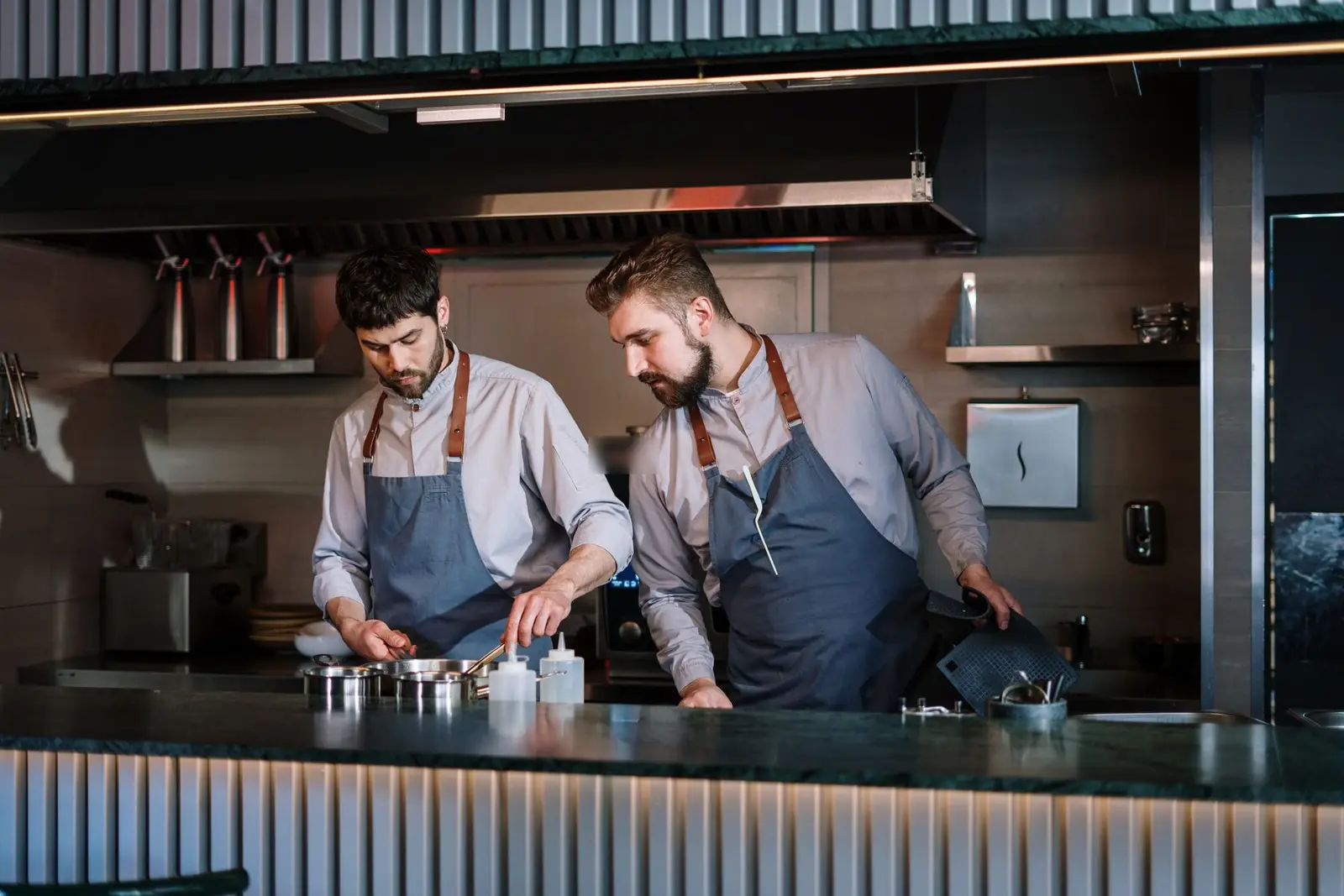 Two chefs in matching aprons in a kitchen