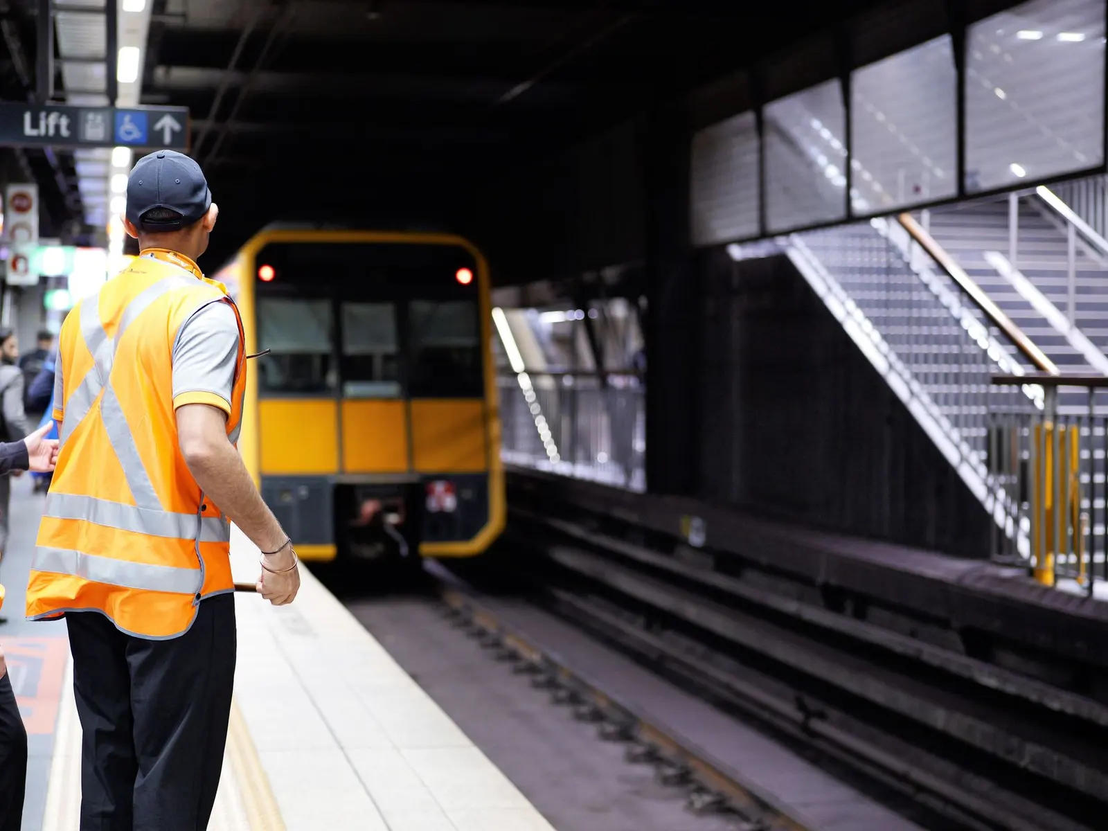 Driver in a day/night hi-vis jacket beside a truck at a loading dock