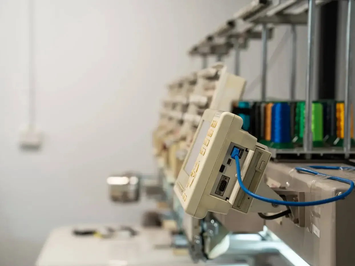 Row of multi-head embroidery machines in the HTG Group workshop