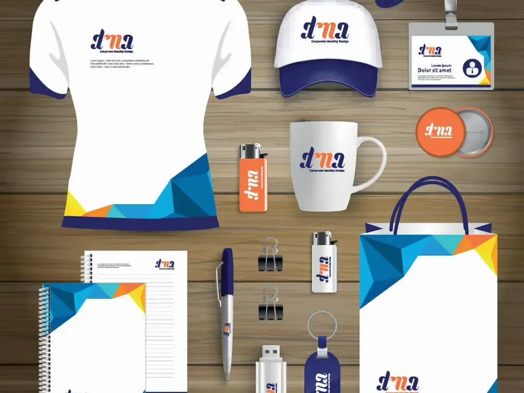 Flatlay of branded promotional products including shirt, caps, mug and notebook