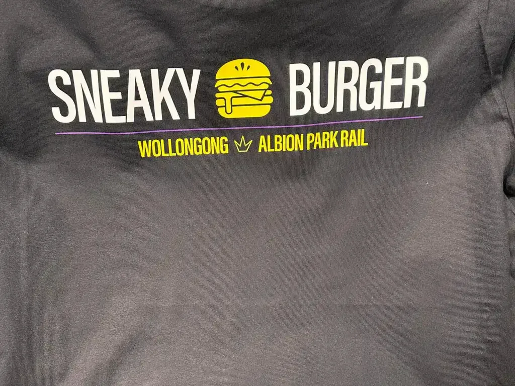 Charcoal tee printed with a burger shop logo