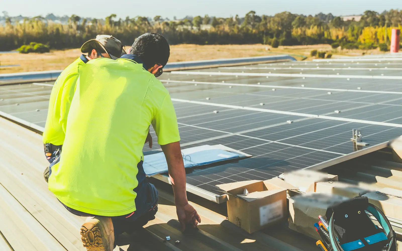 Workers in fluoro hi-vis polos on a solar roof