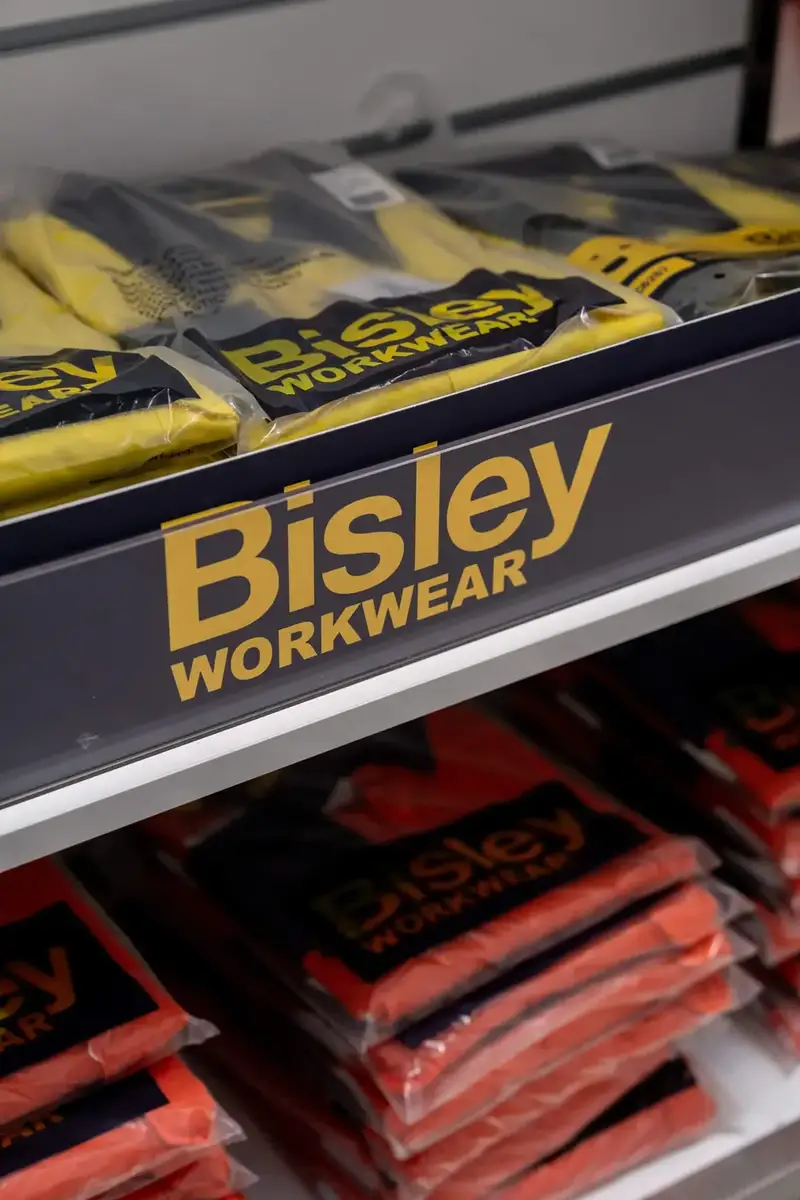 Shelf of folded yellow and orange hi-vis workwear