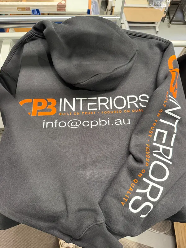 Dark grey hoodie printed with a CPB Interiors logo across the back and down the sleeve