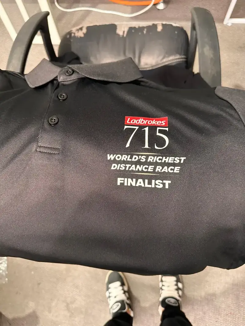 Black polo embroidered with a race finalist logo