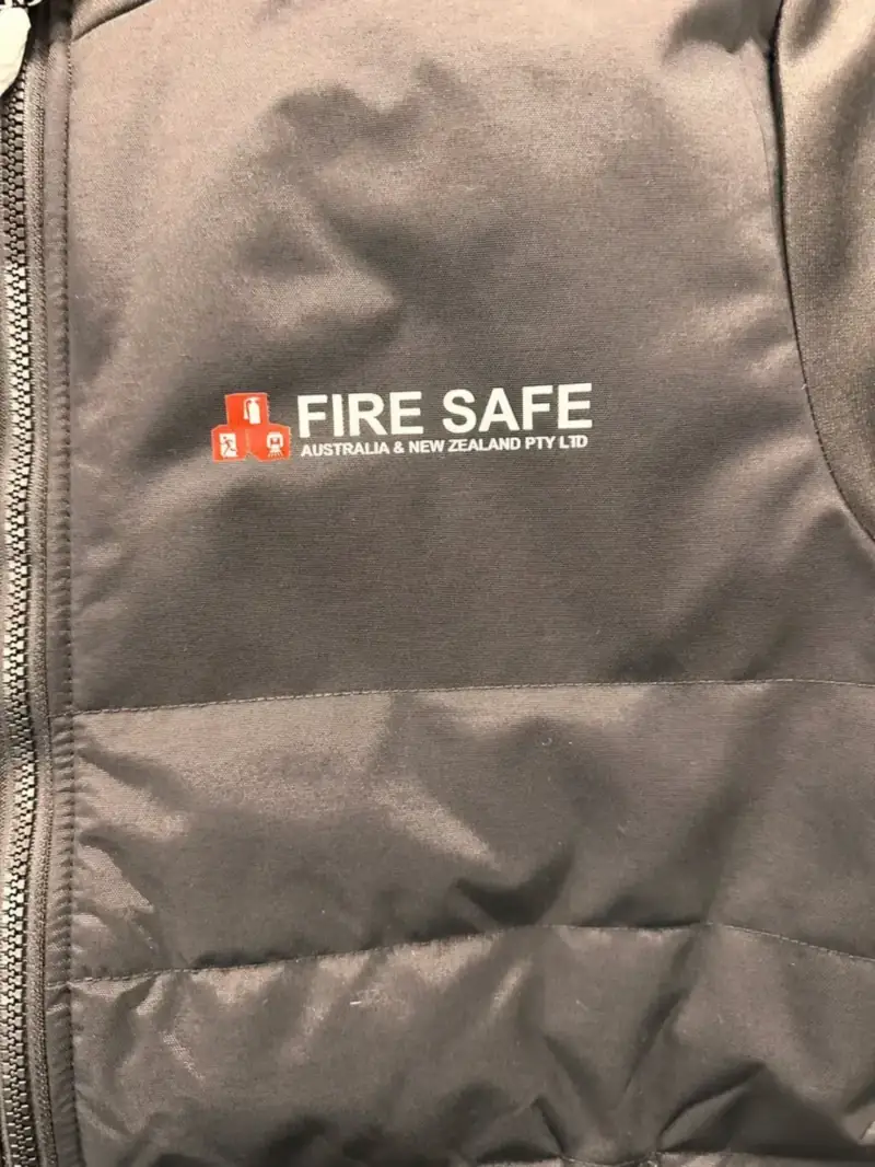 Grey vest embroidered with a fire safety logo