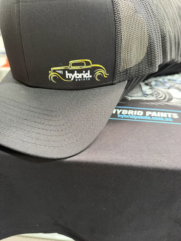 Black trucker cap with an embroidered Hybrid Paints logo and a yellow classic car outline on the front