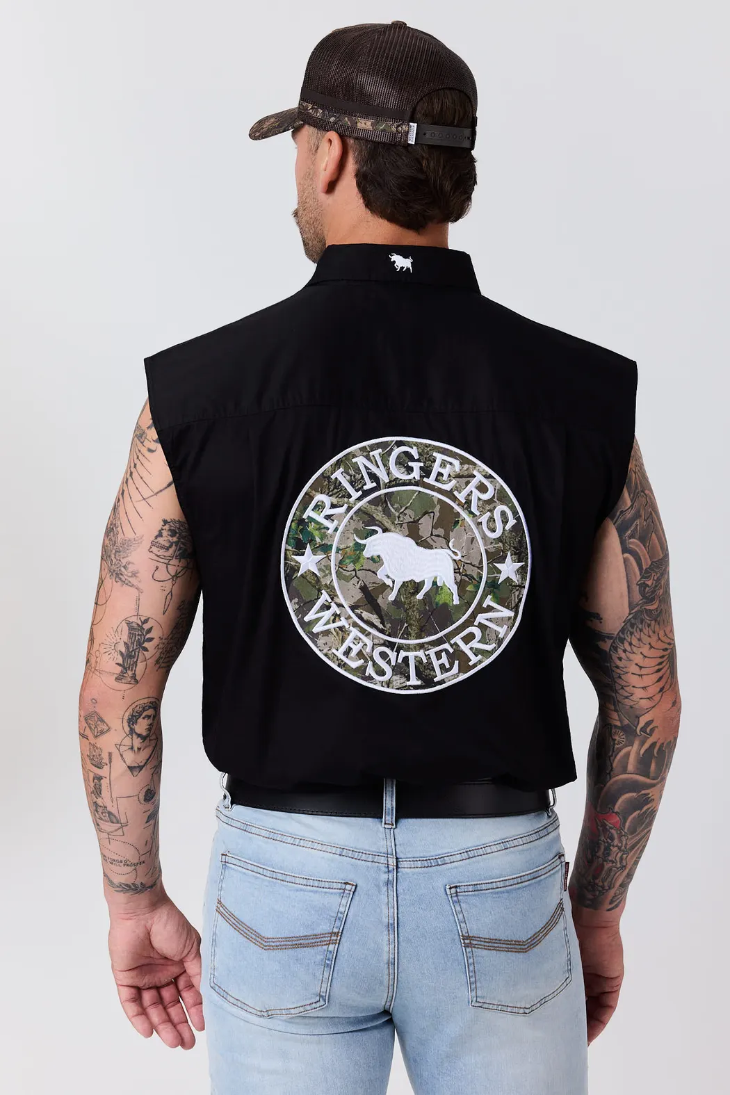 Man in a black sleeveless Ringers Western shirt with a large camo crest on the back