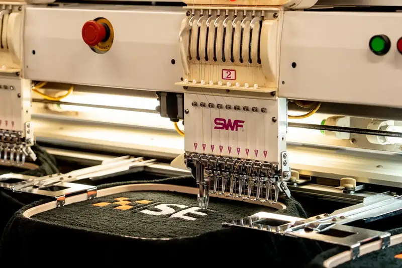 Flood rescue crest being stitched onto a dark garment on an embroidery machine