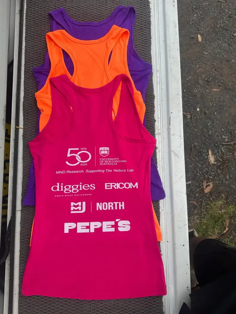 Pink, orange and purple singlets printed with sponsor logos on the back